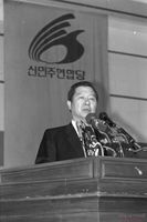 신민주연합당 표식 앞에 선 김대중 썸네일 이미지